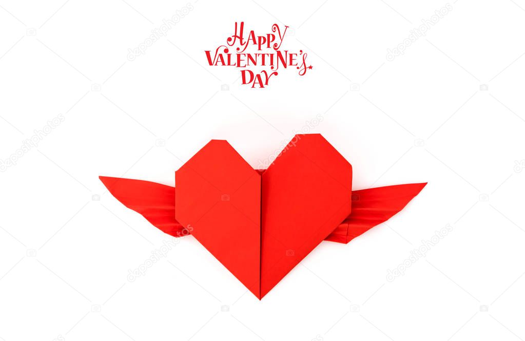 Red paper origami heart with wings on white background .