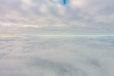 Uçak penceresinden bulutların üzerinde gün doğumu .