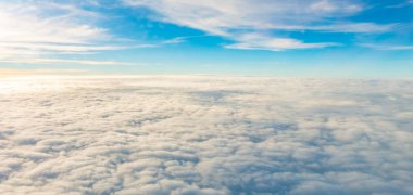 Uçak penceresinden bulutların üzerinde gün doğumu .