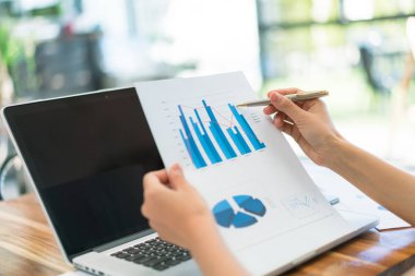 Kapalı toplantıda laptop ve mali grafikleri kullanarak iş adamları