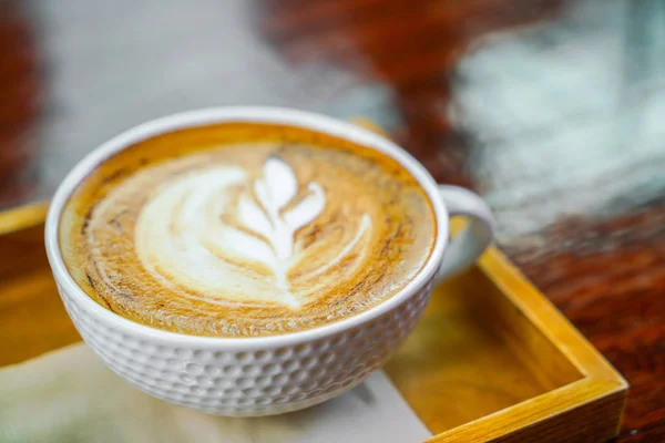 Café Latte arte na mesa de madeira . — Fotografia de Stock