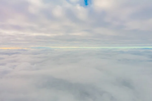 Salida del sol sobre las nubes desde la ventana del avión . —  Fotos de Stock