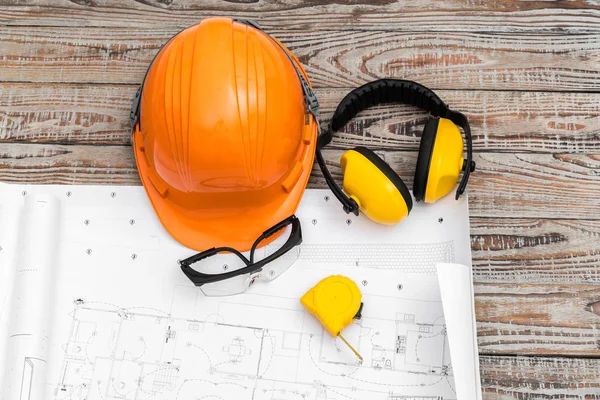 Planes de construcción con casco y herramientas de dibujo en planos  . — Foto de Stock