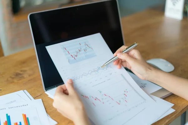 Geschäftsfrau mit Finanzdiagrammen und Laptop auf dem Tisch — Stockfoto