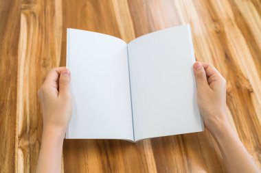 Ahşap masa üzerinde eller açık kitap .