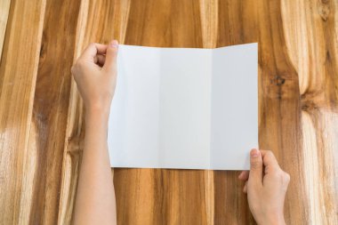 Kadın el tutun panelli beyaz şablon kağıt üzerinde ahşap doku .