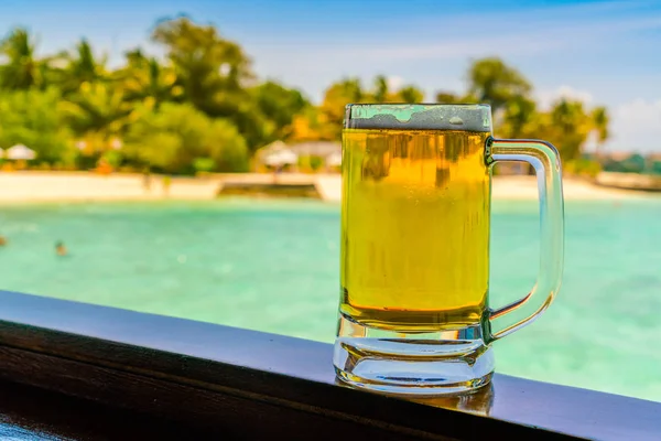 A glass of beer with Beautiful tropical Maldives island . — Stock Photo, Image