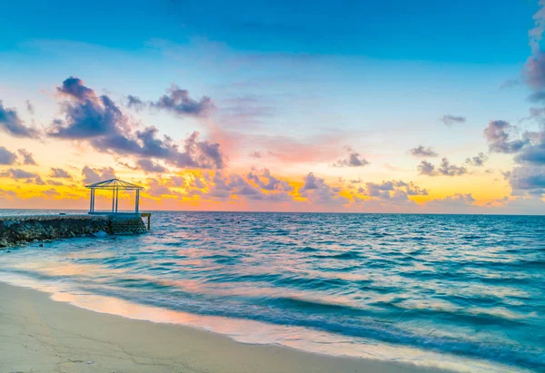 Hermosa puesta de sol con el cielo sobre el mar tranquilo en las Maldivas tropicales es — Foto de Stock