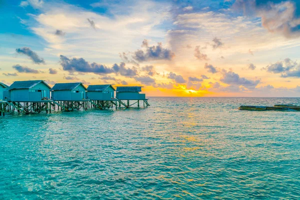 在热带马尔代夫岛日落时美丽的水上别墅 — 图库照片