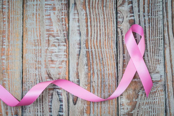 Dia Mundial do Câncer: Fita de Conscientização do Câncer de Mama na Madeira Backgr — Fotografia de Stock