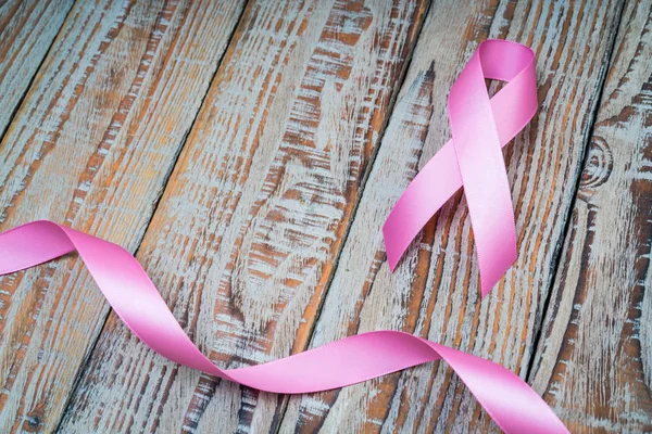 World cancer day : Breast Cancer Awareness Ribbon on wood Backgr