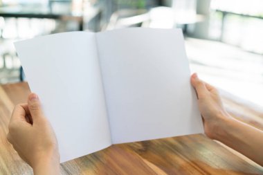 Kadın el tutun Bifold beyaz şablon kağıt üzerinde ahşap doku .