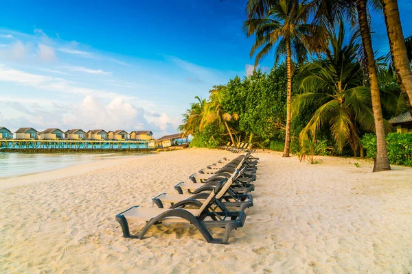 Plaj sandalyeleri Maldivler Island ile güneşin doğuşunu, su Villa