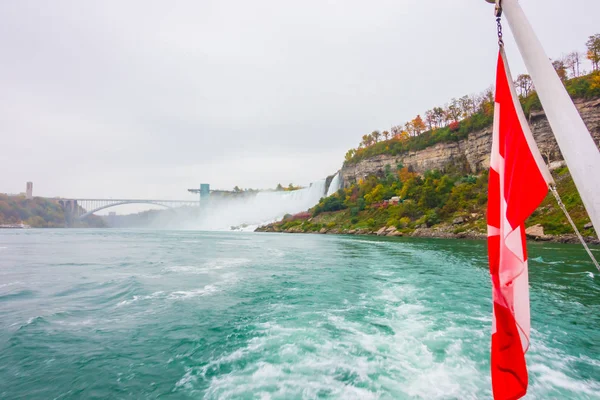 Канадский флаг на лодке у Ниагарского водопада  . — стоковое фото