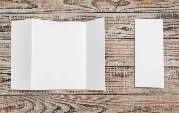 Quatro - papel de modelo branco dobrável na textura da madeira  . — Fotografia de Stock