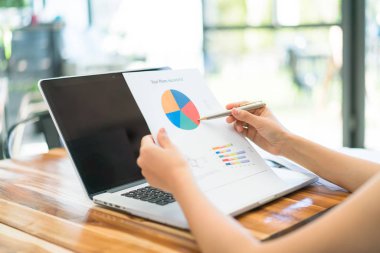 Kapalı toplantıda laptop ve mali grafikleri kullanarak iş adamları