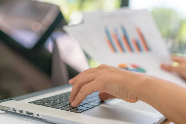 Zakelijke vrouw hand met financiële grafieken en laptop op de tabl — Stockfoto