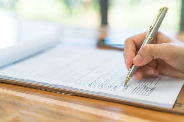 Mano con pluma sobre formulario de solicitud  . — Foto de Stock