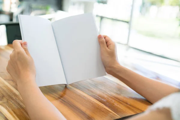 De open boek handen op houten tafel . — Stockfoto