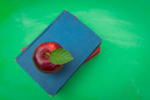 Green blank chalkboard with red apple and book  . — Stock Photo, Image