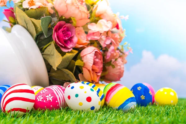 Huevos de Pascua con flor artificial sobre hierba verde fresca — Foto de Stock