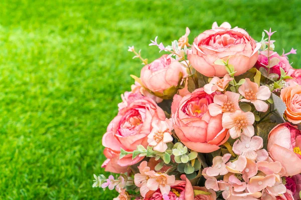 Beautiful of artificial flowers on grass — Stock Photo, Image
