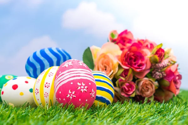 Huevos de Pascua con flor artificial sobre hierba verde fresca — Foto de Stock