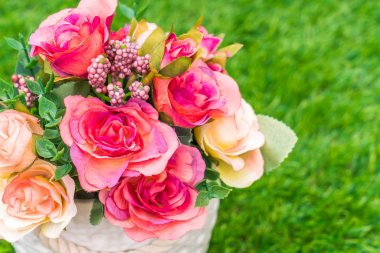 Çimenlerin üzerinde yapay çiçek güzel