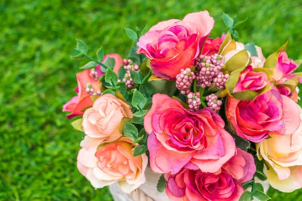 Çimenlerin üzerinde yapay çiçek güzel