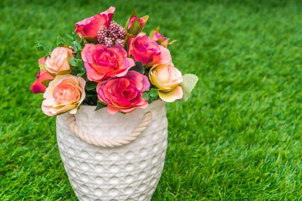 Prachtige kunstbloemen op gras — Stockfoto