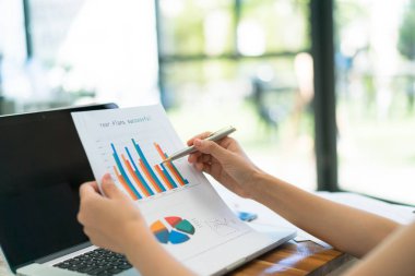 Kapalı toplantıda laptop ve mali grafikleri kullanarak iş adamları