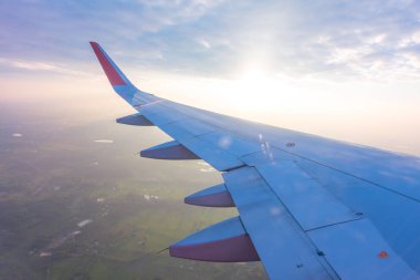 Gün batımında bulutların üzerinde uçan bir uçağın kanadı (filtrelenmiş görüntü işlenmiş vintage etkisi. )