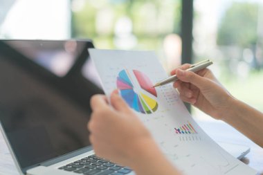 Dizüstü bilgisayar ve mali grafikleri ofis toplantı adlı kullanarak iş adamları