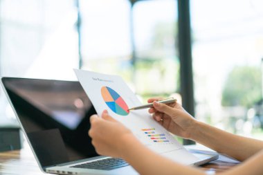 Dizüstü bilgisayar ve mali grafikleri ofis toplantı adlı kullanarak iş adamları