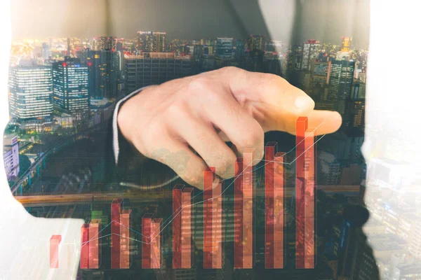 Double exposure of business man touching an imaginary screen with cityscape