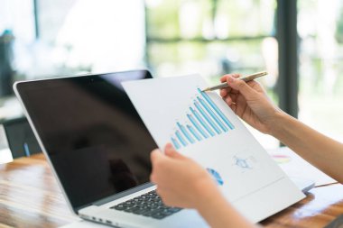 Dizüstü bilgisayar ve mali grafikleri ofis toplantı adlı kullanarak iş adamları