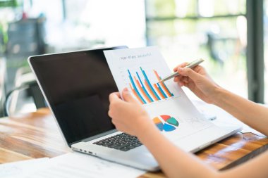 Dizüstü bilgisayar ve mali grafikleri ofis toplantı adlı kullanarak iş adamları