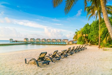 Plaj sandalyeleri Maldivler Island ile güneşin doğuşunu, su Villa