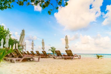 Plaj sandalyeleri Maldivler Island, beyaz kumlu Plajda şemsiye ile