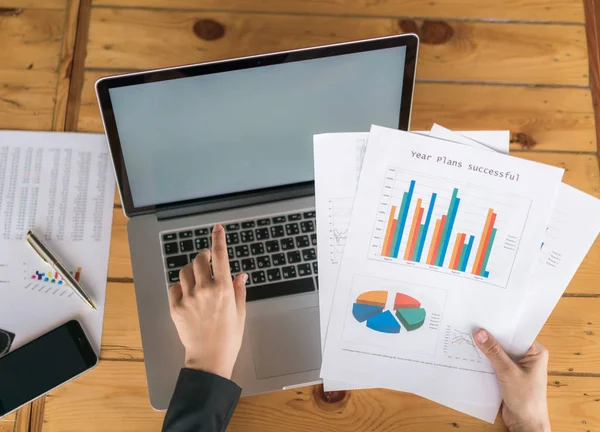 Mão de mulher de negócios com gráficos financeiros e laptop na mesa — Fotografia de Stock