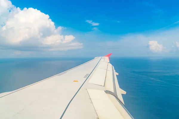 Airplane descending over a blue ocean to maldives island . — Stock Photo, Image