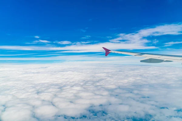 Asa de um avião voando acima das nuvens . — Fotografia de Stock