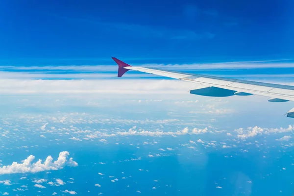 Asa de um avião voando acima das nuvens . — Fotografia de Stock