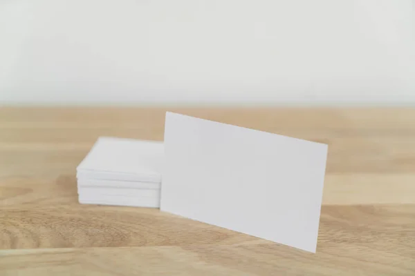 Blank business cards mock up on wooden surface.