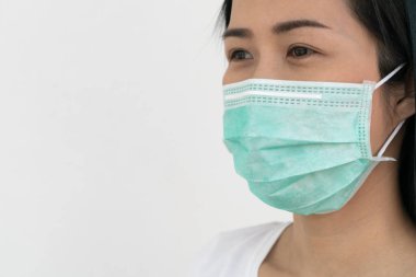 Bir kadın, Coronavirus 'un (COVID-19) yayılmasına karşı koruyucu bir maske takar. Cerrahi maske. Tıbbi maske. Yüz maskesi.