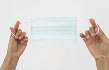 Bir kadın, Coronavirus 'un (COVID-19) yayılmasına karşı koruyucu bir maske takar. Cerrahi maske. Tıbbi maske. Yüz maskesi.