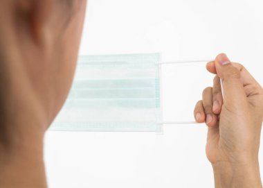 Bir kadın, Coronavirus 'un (COVID-19) yayılmasına karşı koruyucu bir maske takar. Cerrahi maske. Tıbbi maske. Yüz maskesi.