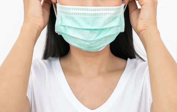 A woman wears a face mask that protects against the spread of Coronavirus (COVID-19). Surgical mask. Medical mask. Face mask.