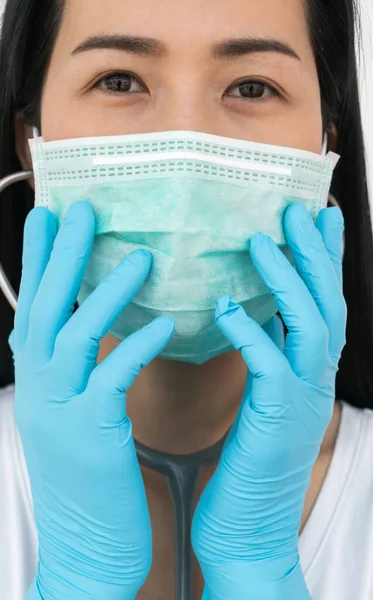 A woman wears a face mask that protects against the spread of Coronavirus (COVID-19). Surgical mask. Medical mask. Face mask.