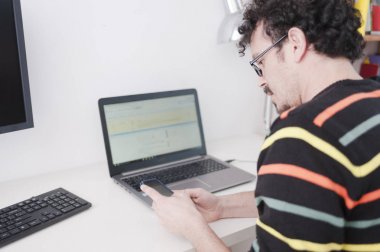 evde masa başında oturan dizüstü kullanan adam